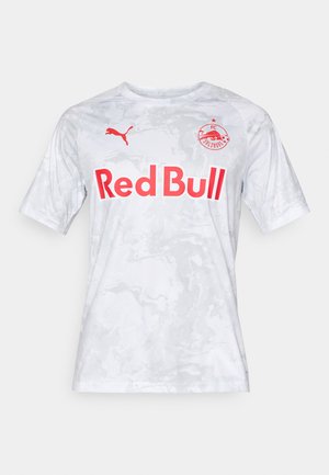 Valge lühikeste varrukatega jalgpallipluus marmorimustriga, punase "Red Bull" logo ja Puma brändinguga vasakul õlal.