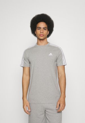 T-shirt sportivo in cotone grigio con design a tre strisce bianche sulle maniche e piccolo logo Adidas sul lato sinistro del petto. Maniche corte.