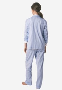 Blauw-wit gestreept pyjama set van lichtgewicht katoen, met een kraag, lange mouwen en een recht gesneden broek.