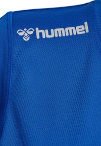 Niebieski sportowy top wykonany z teksturowanej tkaniny, z białym logo. Ma dopasowany krój z widocznymi detalami szwów.