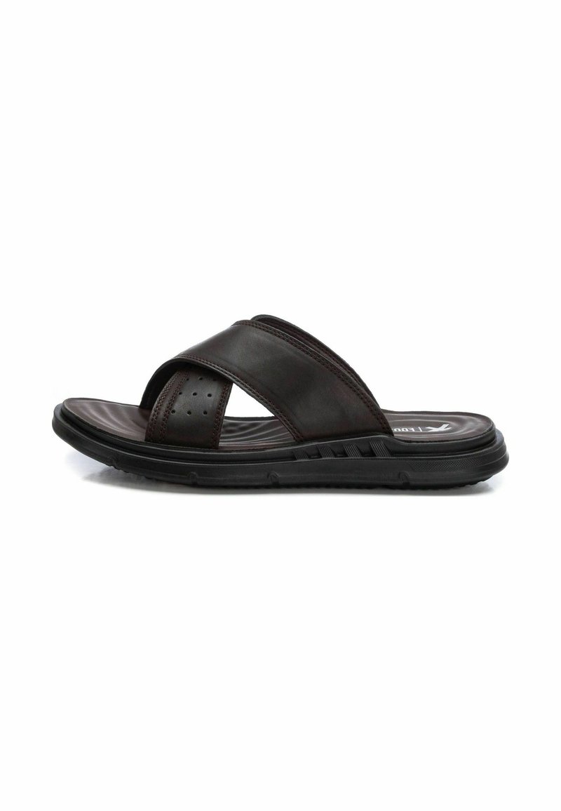 Sandalias deslizables de cuero marrón con dos cintas curvas, acentos perforados, una plantilla texturizada y una suela de goma negra flexible.