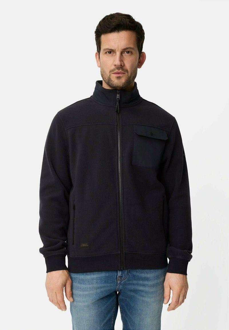 Dunkelblaue Fleecejacke mit hohem Kragen, Frontreißverschluss und Brusttasche. Verfügt über gerippte Bündchen und ein goldenes Logodetail am Saum.