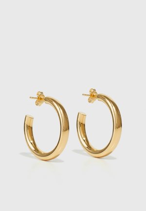 Boucles d'oreilles en or en forme de cercle, avec une surface lisse et polie. Fermeture à clip pour un enfilage facile.