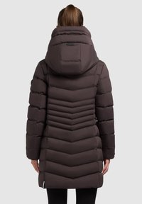Puffer jacket in dark brown with a fitted silhouette, chevron pattern details on the back, and a large, padded hood. Smooth texture.