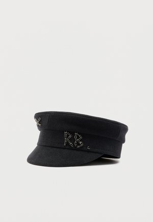 Schwarze Stoffkappe mit kurzem Schirm, verziert mit kleinen silbernen Nieten, die "RB" formen, und einem Kreuzdetail an der Seite.