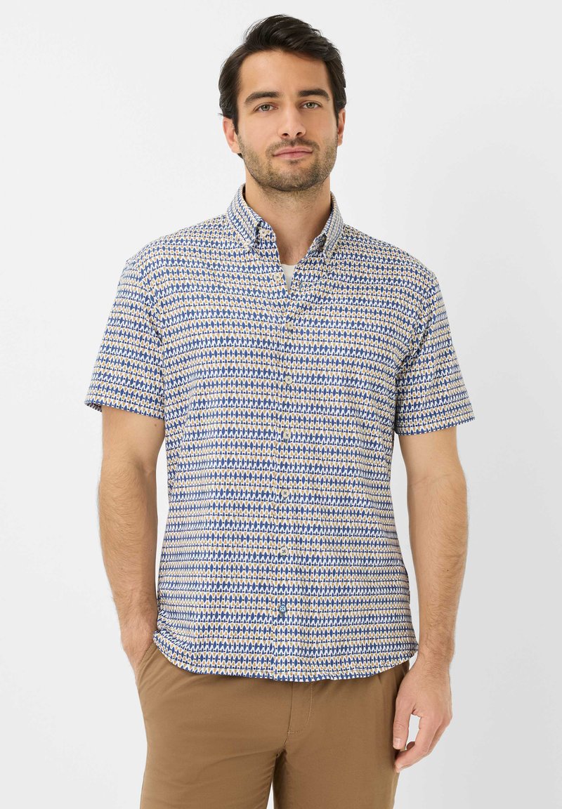 Camicia a maniche corte con bottoni di colore bianco, decorata con un motivo geometrico blu e giallo, dotata di colletto e vestibilità comoda.