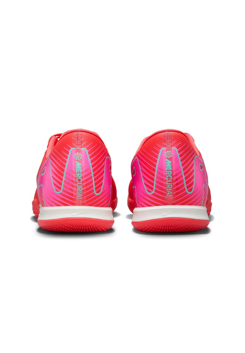 Czerwono-różowe buty sportowe z teksturowaną powierzchnią, z białą podeszwą i niebieskimi akcentami. Podwójne tylnie logo zawiera napis "Mercurial."