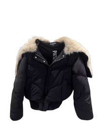 Giacca a vento nera con colletto di pelliccia sintetica beige, zip frontale, bottoni a scatto e tasche laterali, esposta su uno sfondo bianco.