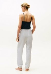 Marineblauw tanktop met kantafwerking, gecombineerd met lichtgrijze joggerbroeken. De joggers hebben elastische boorden en een comfortabele tailleband.