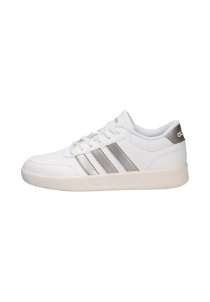 Chaussure de sport blanche avec des accents argentés, design à lacets, en matériau synthétique lisse, bout arrondi, avec trois bandes parallèles sur le côté.