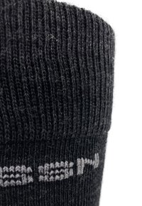 Schwarze gestrickte Socke mit geribbelter Struktur und einem grauen gewebten Akzentmuster. Der obere Rand ist mit einem engen Bündchen versehen.