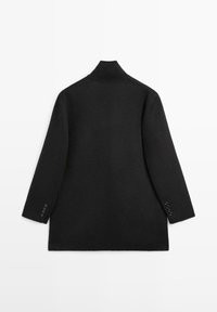 Cappotto in misto lana nero con alto colletto, maniche lunghe e dettagli in bottone sui polsini. Tessuto morbido, design minimal e forma sartoriale.