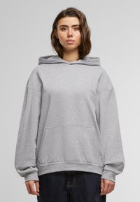 Felpa grigia con cappuccio, maniche lunghe e tasca a marsupio frontale. Realizzata in tessuto morbido con vestibilità comoda e orlo a costine.
