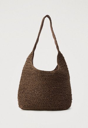 Sac d'épaule en paille tressée marron avec une seule sangle souple et une ouverture incurvée sur un fond clair uni.