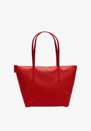 Czerwona torba na ramię ze skóry z podwójnymi uchwytami i małym zielonym logo krokodyla umieszczonym centralnie u góry.