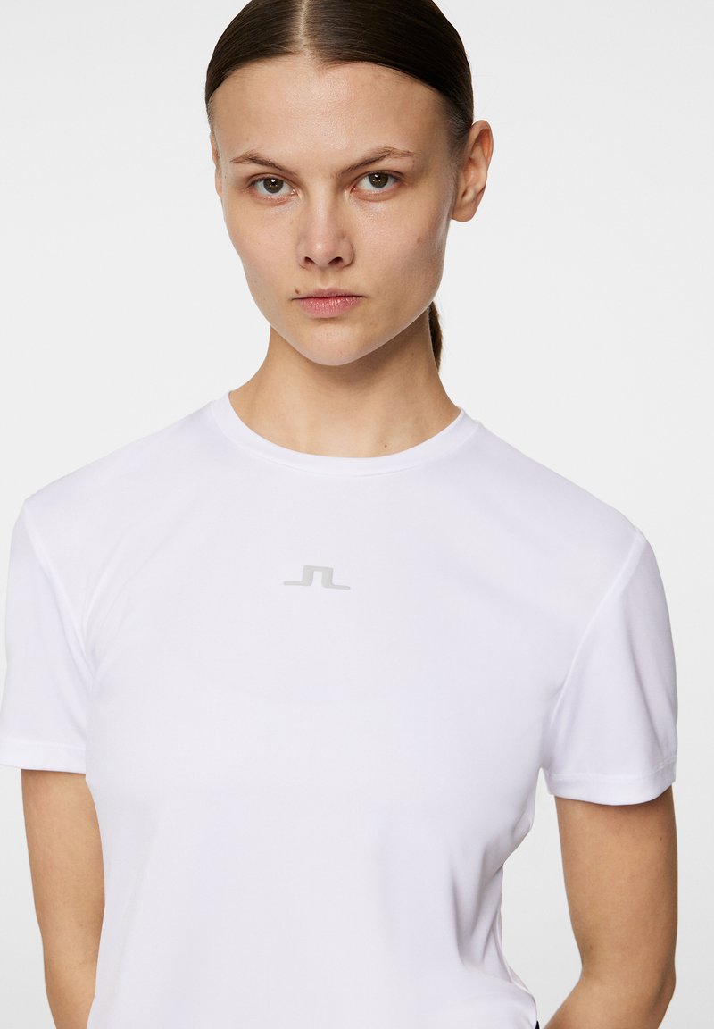 T-shirt atletico bianco a maniche corte con scollatura rotonda e logo silver sul petto. Tessuto liscio con design aderente.