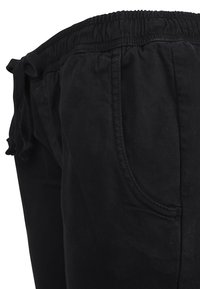 Svarta joggerbyxor i blandad bomullstyg. Har resårmidja och sidofickor, med avslappnad passform och slät yta.