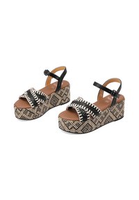 Sandali platform neri e beige con cinturini intrecciati, una zeppa con un motivo geometrico testurizzato e cinturini alla caviglia regolabili.