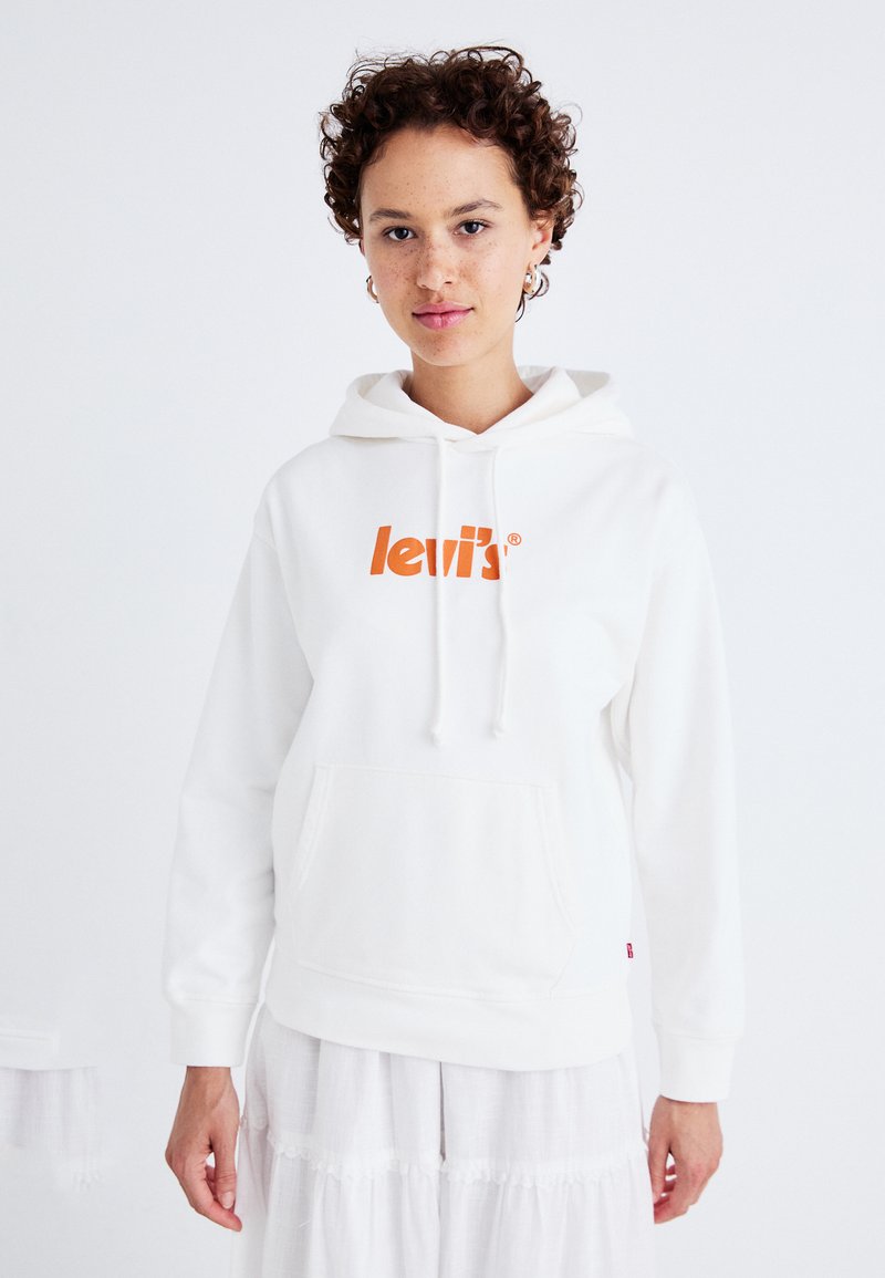 Vit hoodie med känguruficka, har en orange "Levi's"-logotyp. Har en dragkedjehuva och ribbade ärmslut. Enkel design, mjuk textur.
