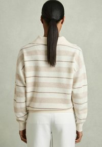 Stripet sweatshirt i blødt cremet og beige uldblanding, med en afslappet pasform, ribbede manchetter og en foldet krave. Simpelt, hyggeligt design.