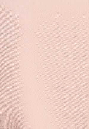 Tissu texturé rose clair avec un tissage diagonal fin, surface lisse et léger éclat, adapté pour des applications vestimentaires ou de tapisserie.