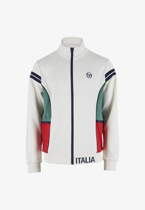 Fehér cipzáros dzseki zöld és piros oldalsávokkal, tengerészkék csíkokkal az ujjakon, "Italia" felirattal az alján és kis kerek logóval a mellkason.