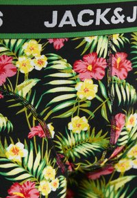 Sous-vêtements pour hommes avec une base noire ornée d'un motif floral vibrant en rouge et en jaune, accentués par une ceinture élastique verte avec le texte "JACK & JONES".