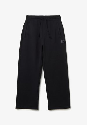 Schwarze Jogginghose aus weichem Baumwollgemisch, mit elastischem Bund und Zugkordel, Seitentaschen und einem Logo-Patch an der Hüfte.