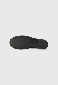 Schwarze Schuhsohle mit glatter Textur, abgerundetem Zeh und deutlich sichtbaren Rillen. Minimalistisches Design, keine sichtbaren Marken oder dekorativen Elemente.