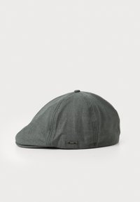 Casquette en tissu gris avec une forme arrondie, un pic plat et une texture subtile. Présente une petite étiquette de logo noire sur le côté.