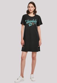 Schwarzes T-Shirt-Kleid mit türkisfarbenem "Honolulu"-Text und floralen Akzenten, kurzen Ärmeln, lockerer Passform und einer Länge bis zur Mitte des Oberschenkels.
