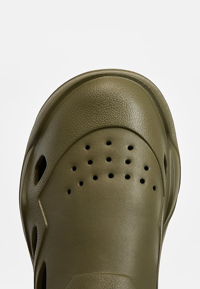 Sabot en caoutchouc vert olive avec surface texturée et trous de ventilation sur le dessus et les côtés.