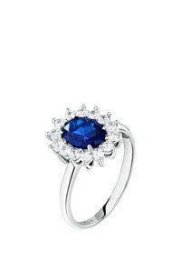 Anello con pietra preziosa ovale blu dalla superficie sfaccettata, circondata da sette diamanti taglio brillante rotondi, montato su una fascia in metallo bianco lucido.