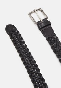 Cinturón de cuero trenzado negro con una hebilla rectangular de metal plateado. La correa presenta un acabado liso y una punta afilada.