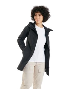 Schwarze wasserdichte Jacke mit Kapuze, ausgestattet mit einem Reißverschluss vorne, Seitentaschen und einem figurbetonten Design. Getragen über einem weißen T-Shirt und beigen Cargo-Hosen.