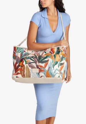 Borsa a tracolla ricamata con motivi di foglie colorate, base in crema solido, dettagli in pelle e una frangia decorativa. Presenta manici doppi.