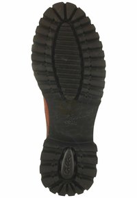 Black rubber shoe sole with deep treads for traction. Features a rounded shape and includes manufacturer branding on the side.