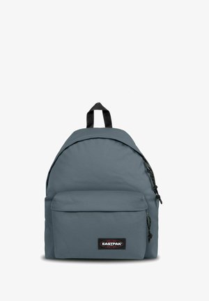 Mochila de tela gris con parte superior redondeada, bolsillo frontal y acentos en negro. Cuenta con correas ajustables y un asa en la parte superior.