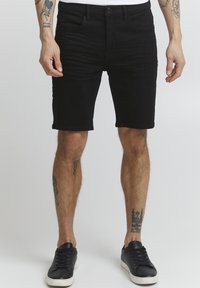 Shorts din denim negru, cu o croială slim, având cinci buzunare și închidere cu nasture. Materialul are o textură fină, ajungând până la mijlocul coapsei.