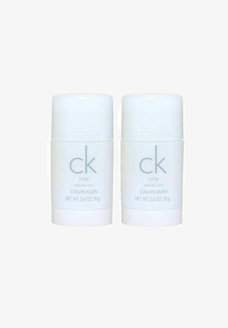 To hvide deodorantstænger med cylindrisk form, der har lys grå tekst "ck one deodorant Calvin Klein", 75 g hver. Glat overflade.