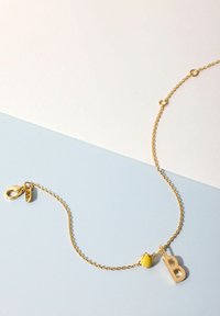 Goldene Kettenarmband mit einer gelben Perle und einem großen "B"-Charm. Verfügt über einen Karabinerverschluss und einen kleinen Blätterakzent. Glatte Textur, schlichtes Design.