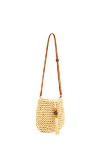 Torbka typu crossbody z plecionego słomy w kolorze beżowym z brązowym, regulowanym paskiem. Ozdobiona dekoracyjną frędzelką i drewnianymi koralikami.