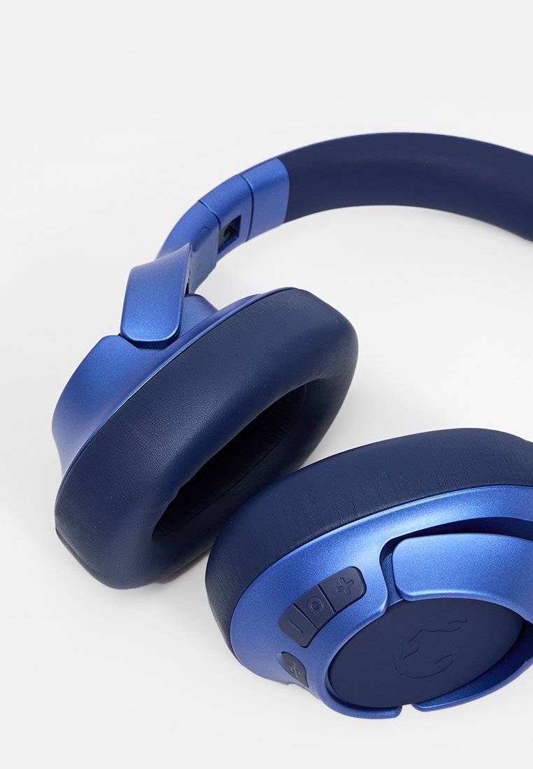 Kabellose Kopfhörer in mattem königsblau mit gepolsterten Ohrpolstern, verstellbarem Kopfband und seitlichen Steuerungstasten für Lautstärke und Wiedergabe.