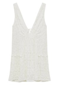 Valkoinen pitsitoppi V-pääntiellä ja säädettävällä soljella, jossa on liehuva muoto ja kukkakuvioita koko kankaan pinnalla.