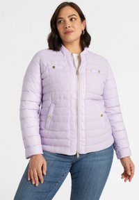 Giacca a vento di colore lilla chiaro con texture trapuntata, chiusura con zip, due tasche sul petto e polsini a coste. Presenta dettagli in metallo color oro.