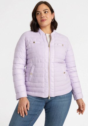 Giacca a vento di colore lilla chiaro con texture trapuntata, chiusura con zip, due tasche sul petto e polsini a coste. Presenta dettagli in metallo color oro.