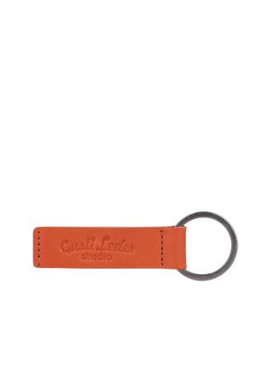 Brauner Leder-Schlüsselanhänger mit geprägt "Gusti Leder studio" Text, befestigt an einem silbernen Metall-Split-Schlüsselring.