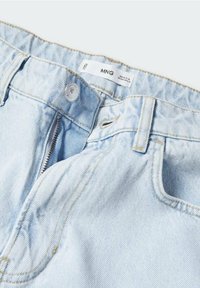 Světle modré džínové kalhoty s zipovým zapínáním, knoflíkovým uzávěrem a štítkem MNG. Látka má jemnou strukturu s mírným vyblednutím a akcenty šití.