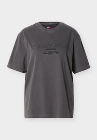 Σκούρο γκρι κοντομάνικο T-shirt με στρογγυλή λαιμόκοψη και κεντημένο κείμενο "Tommy Jeans Since 1985 New York City" στο μπροστινό μέρος.