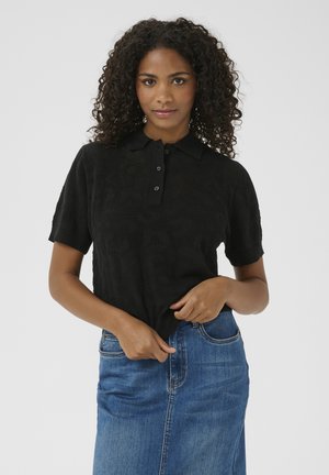 Zwart polo shirt met korte mouwen en een textuurpatroon, voorzien van een klassieke kraag en een drie-knopenrij, gecombineerd met een spijkerrok.